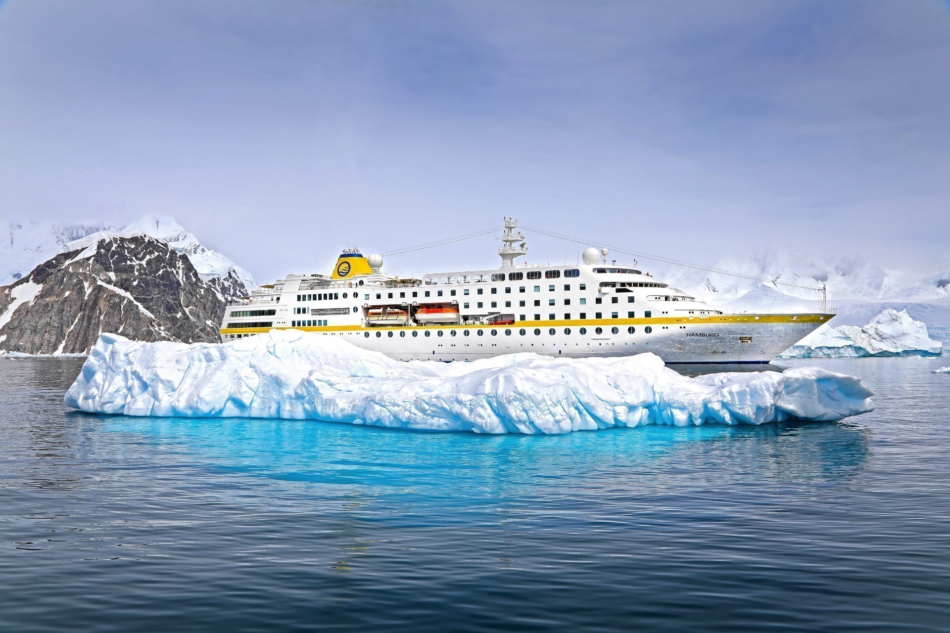 Antarktis Kreuzfahrt Bremen: Die MS Hamburg der Reederei Plantours auf Antarktis-Kreuzfahrt vor einer großen EIsscholle.