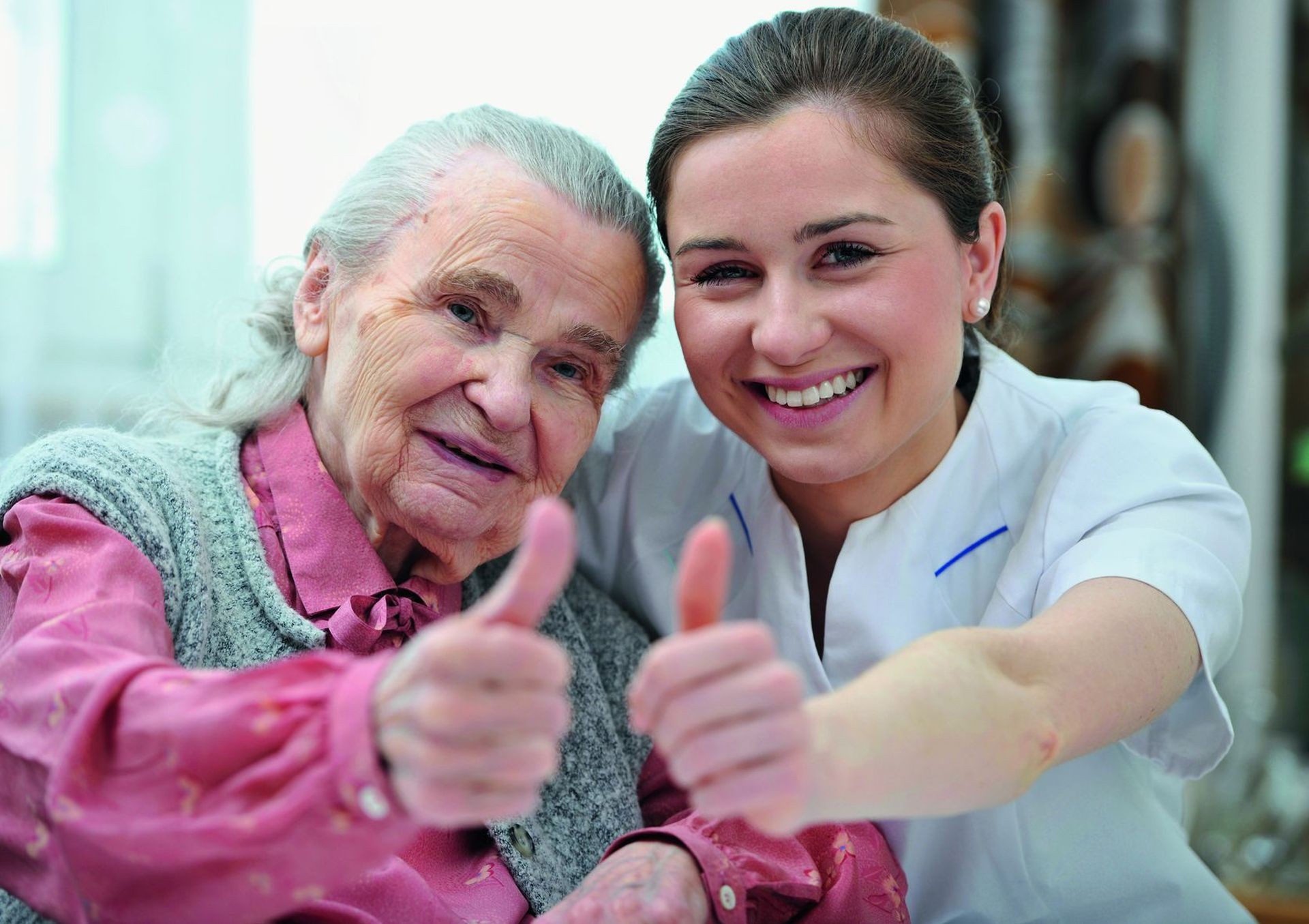 Pflegedienstleitung und Seniorin blicken zufrieden in die Zukunft.