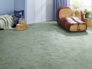 Grüner Vorwerk-Teppich verlegt in einem Privatzimmer.