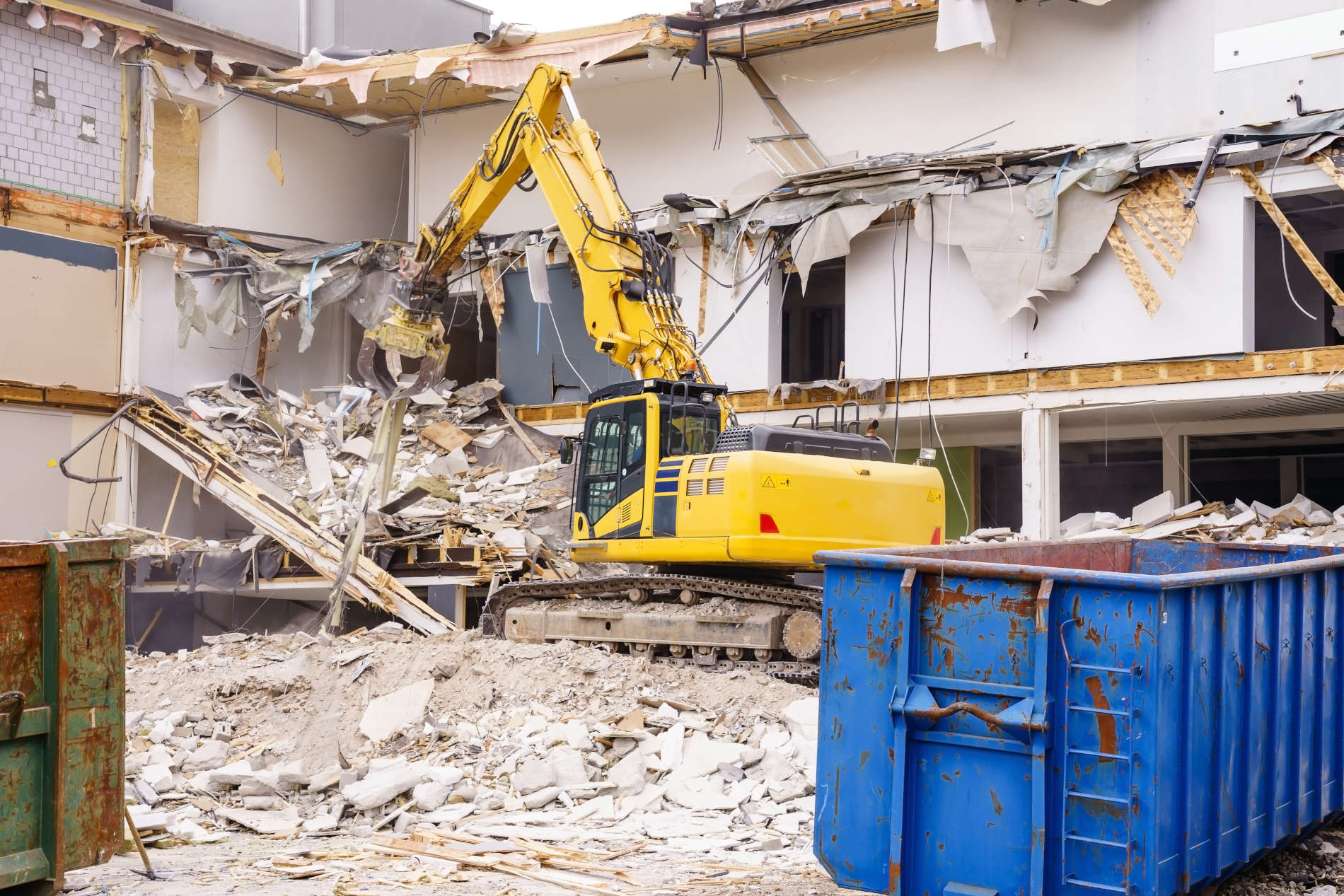 Abbruch Bremen: Ein gelber Bagger steht vor einem Gebäude, das abgerissen wird