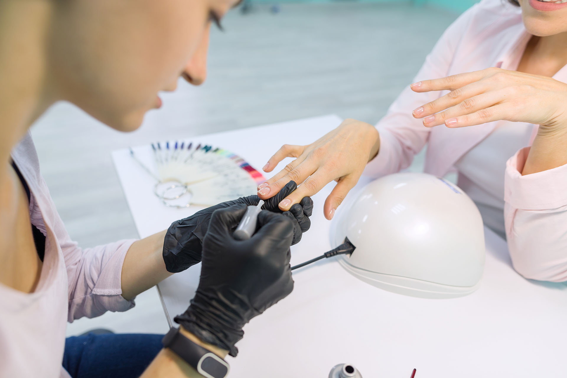Detailansicht einer professionellen Maniküre mit Nagellackanwendung, Darstellung von Expertise in Nagelpflege und Nageldesign