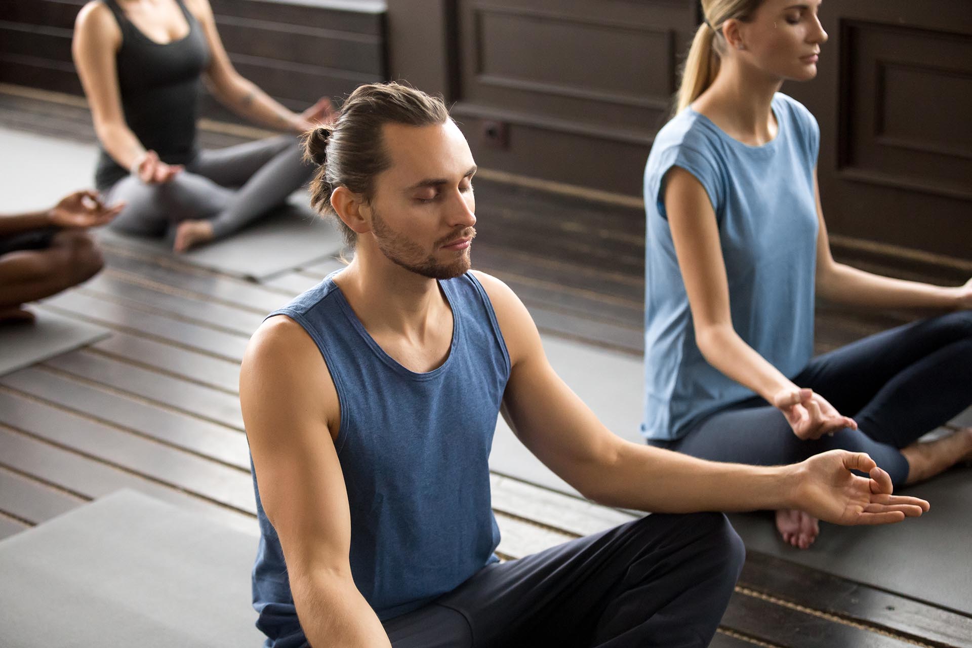 Mehrere Personen in Meditation in einem Yoga-Studio