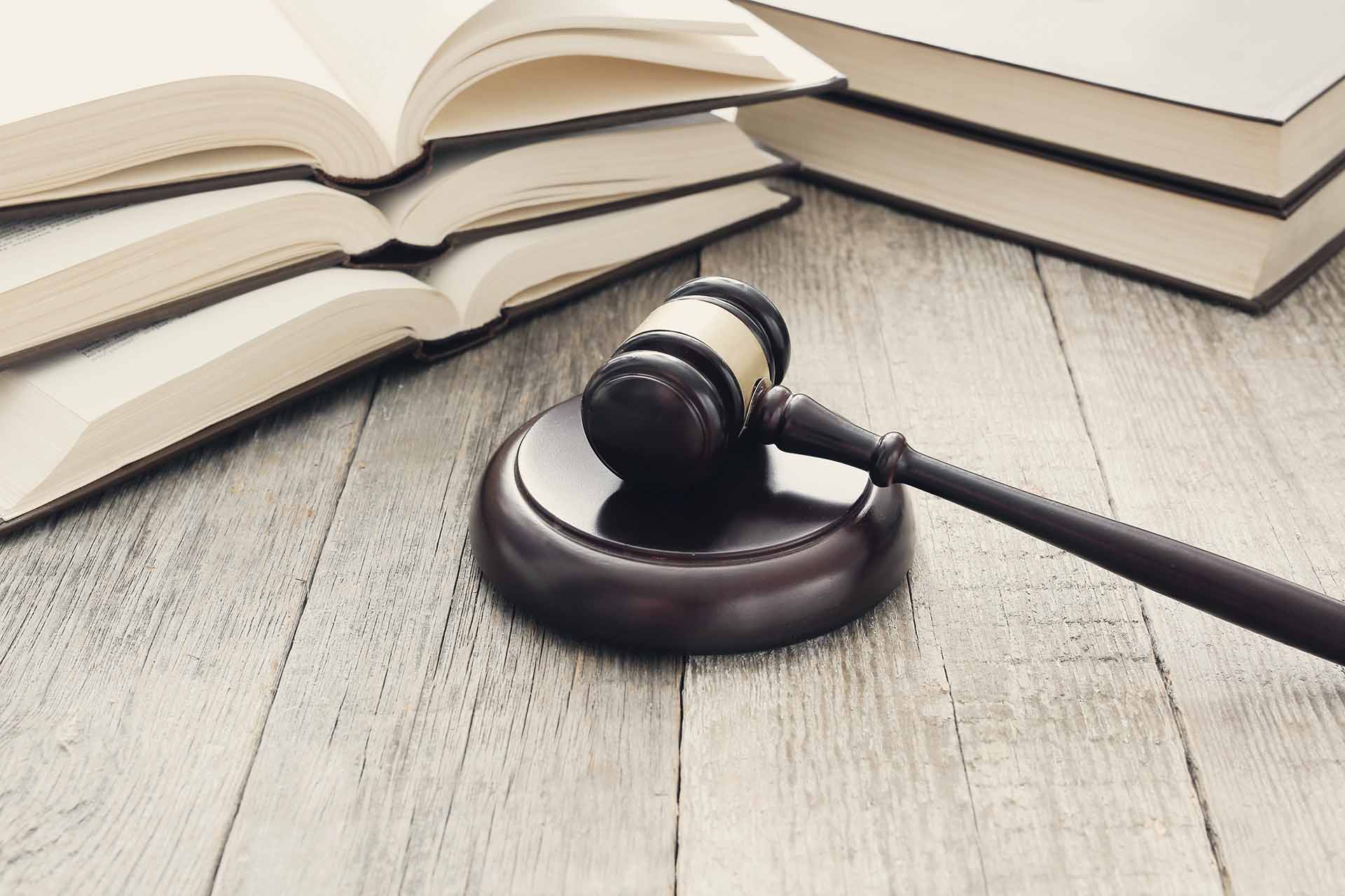 Stapel von Gesetzbüchern und juristischen Dokumenten, Darstellung von rechtlichen Grundlagen und Wissen