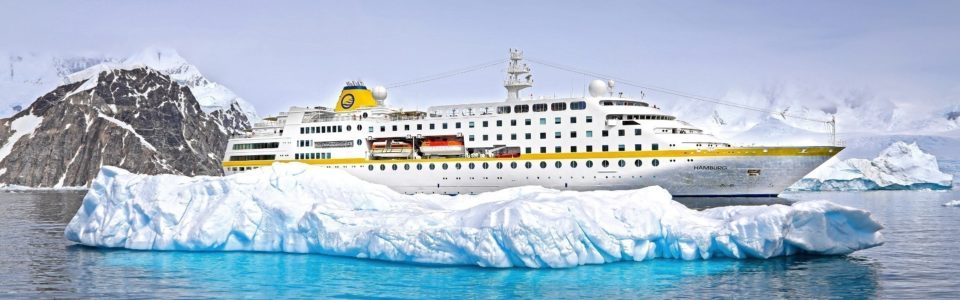 Antarktis Kreuzfahrt Bremen: Die MS Hamburg der Reederei Plantours auf Antarktis-Kreuzfahrt vor einer großen EIsscholle.