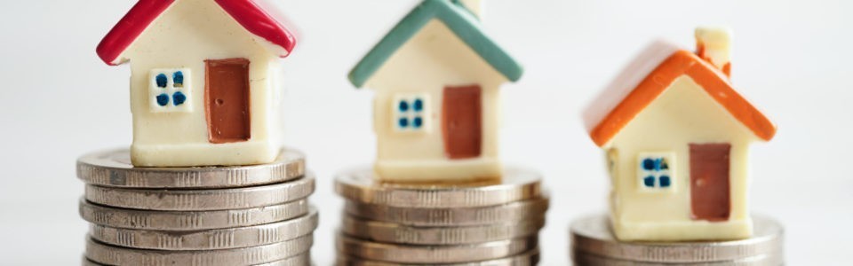 Kaufnebenkosten Bremen: Miniaturhäuser stehen auf Geldtürmen