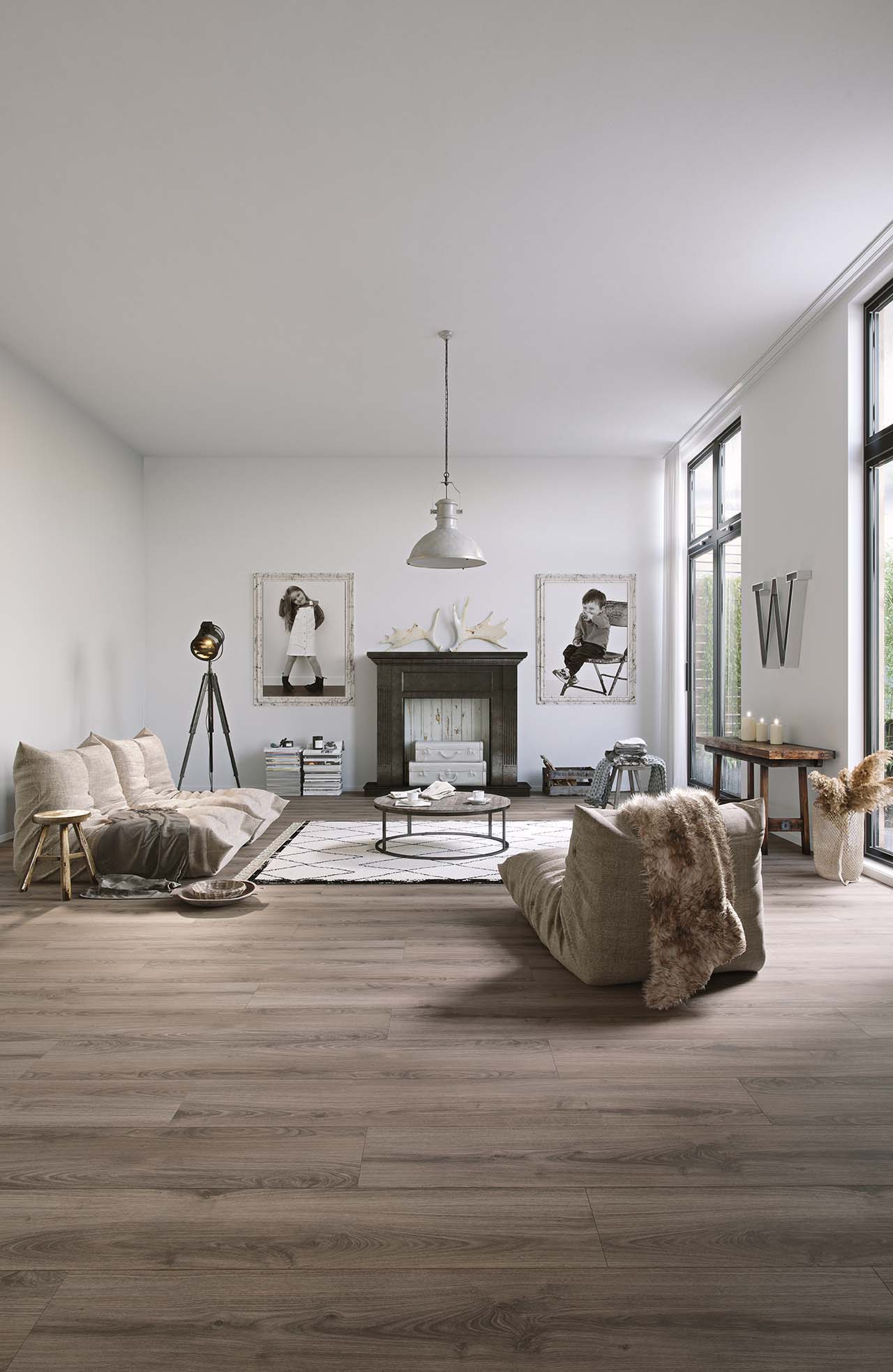 Helles Wohnzimmer mit Bioboden in Holzoptik, Kamin und großen Fenstern für viel Tageslicht.
