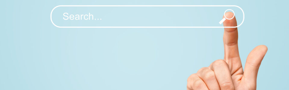 Finger zeigt auf virtuelle Suchleiste vor blauem Hintergrund – Symbolbild für Online-Suche und SEO vie KeywordKönig